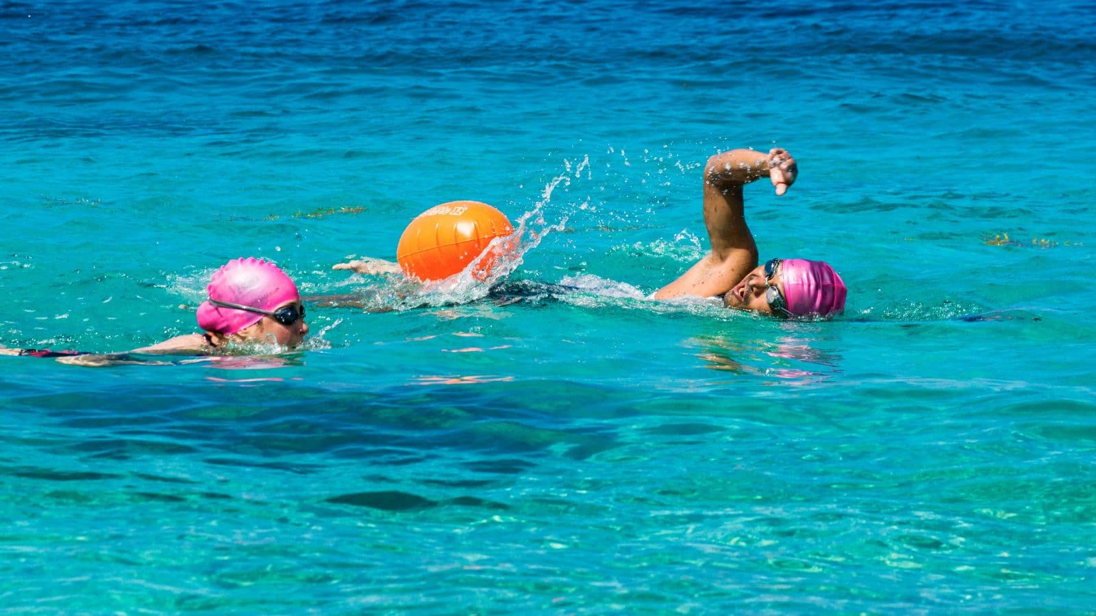 Triathlete sighting toward a turn buoy while approaching it during an open water swimming race.