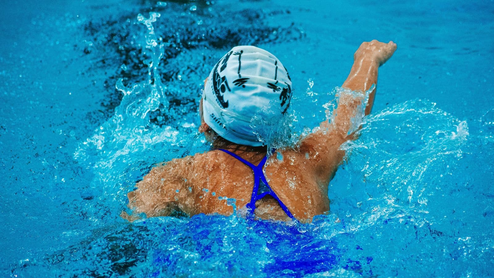 Triathlete starting from the outside edge of a crowded open-water swim to avoid heavy contact with other swimmers.