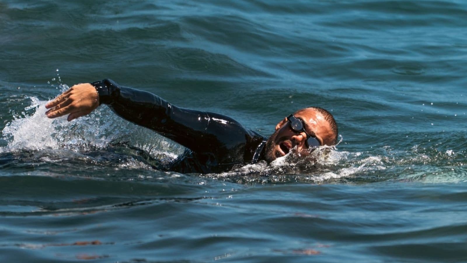 Triathlete practising relaxed bilateral breathing during a freestyle swim to improve efficiency and reduce anxiety.