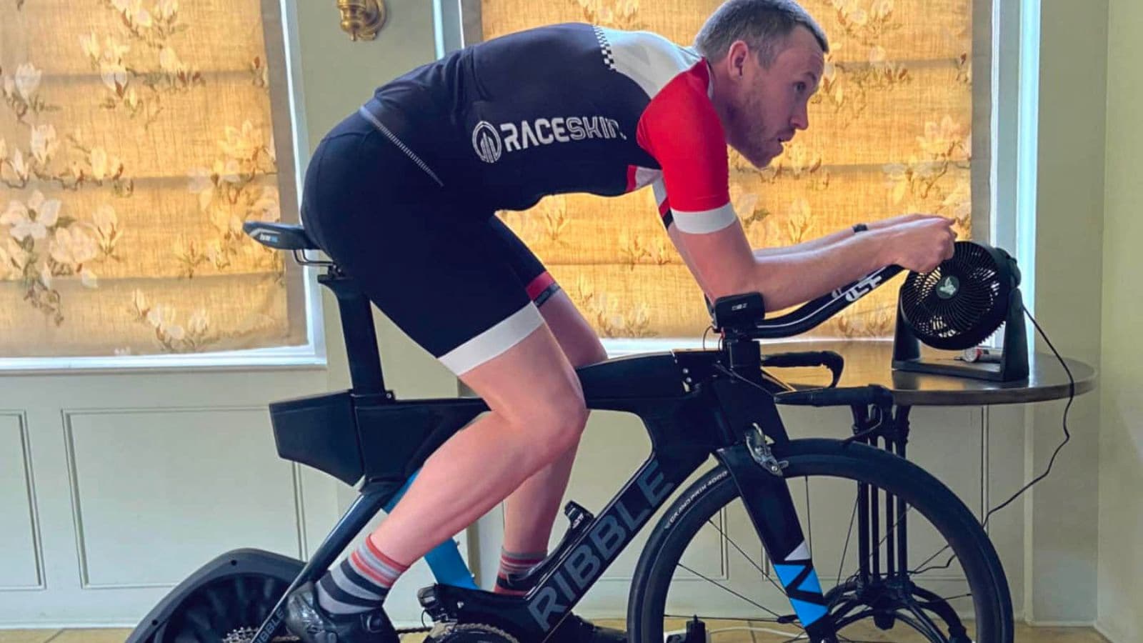 Triathlete increasing cycling intensity during shorter efforts in a descending interval workout on a triathlon bike.