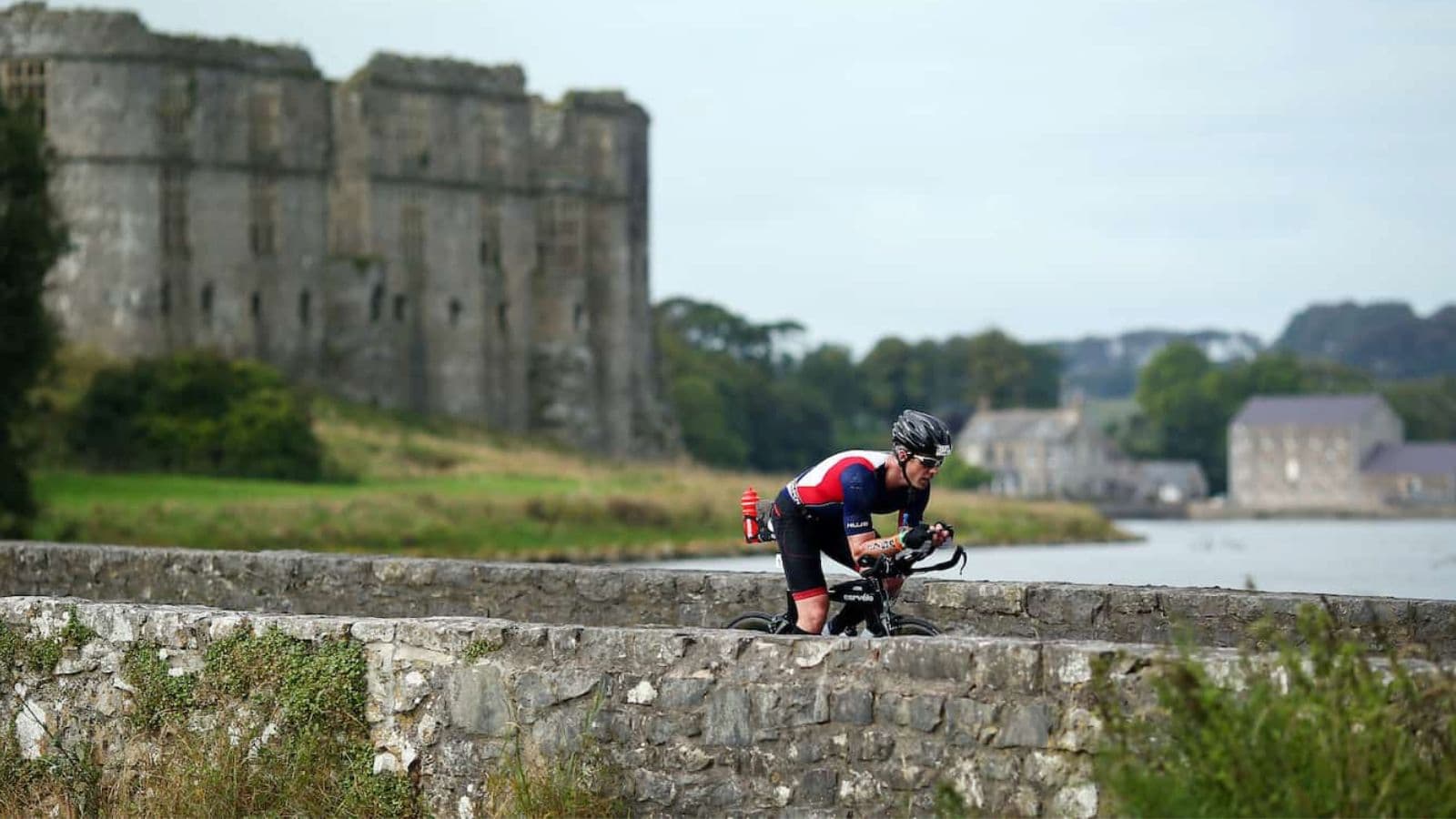 Triathlete riding a cyclocross bike on a muddy off-road course to improve bike handling skills for triathlon.