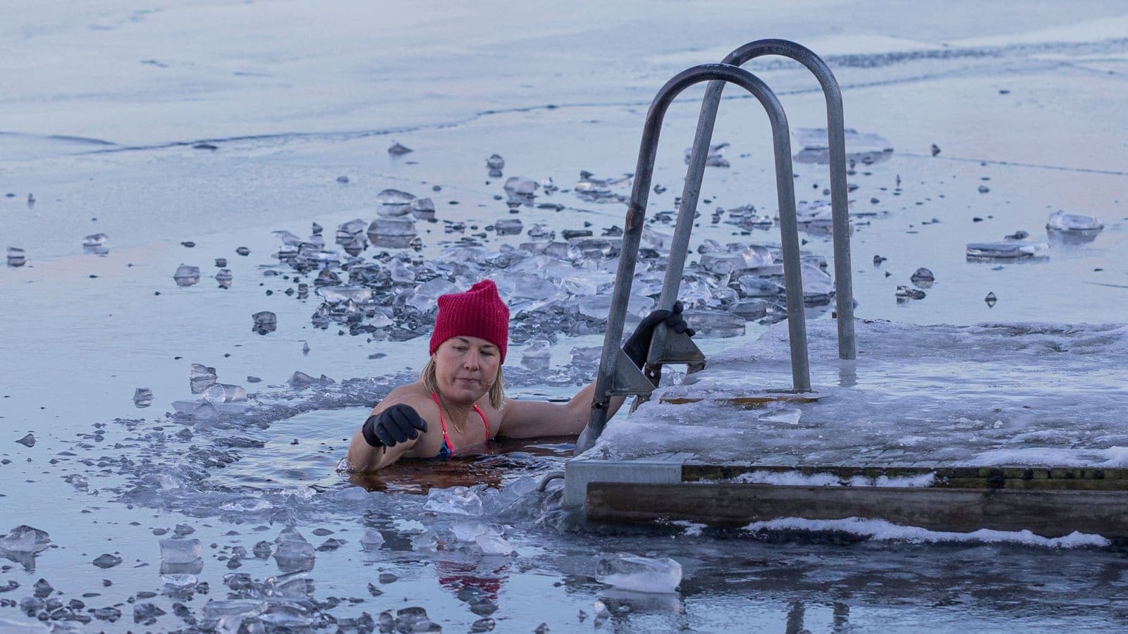 Triathlete sitting in a cold-water recovery bath after a demanding swim, bike, and run training session.