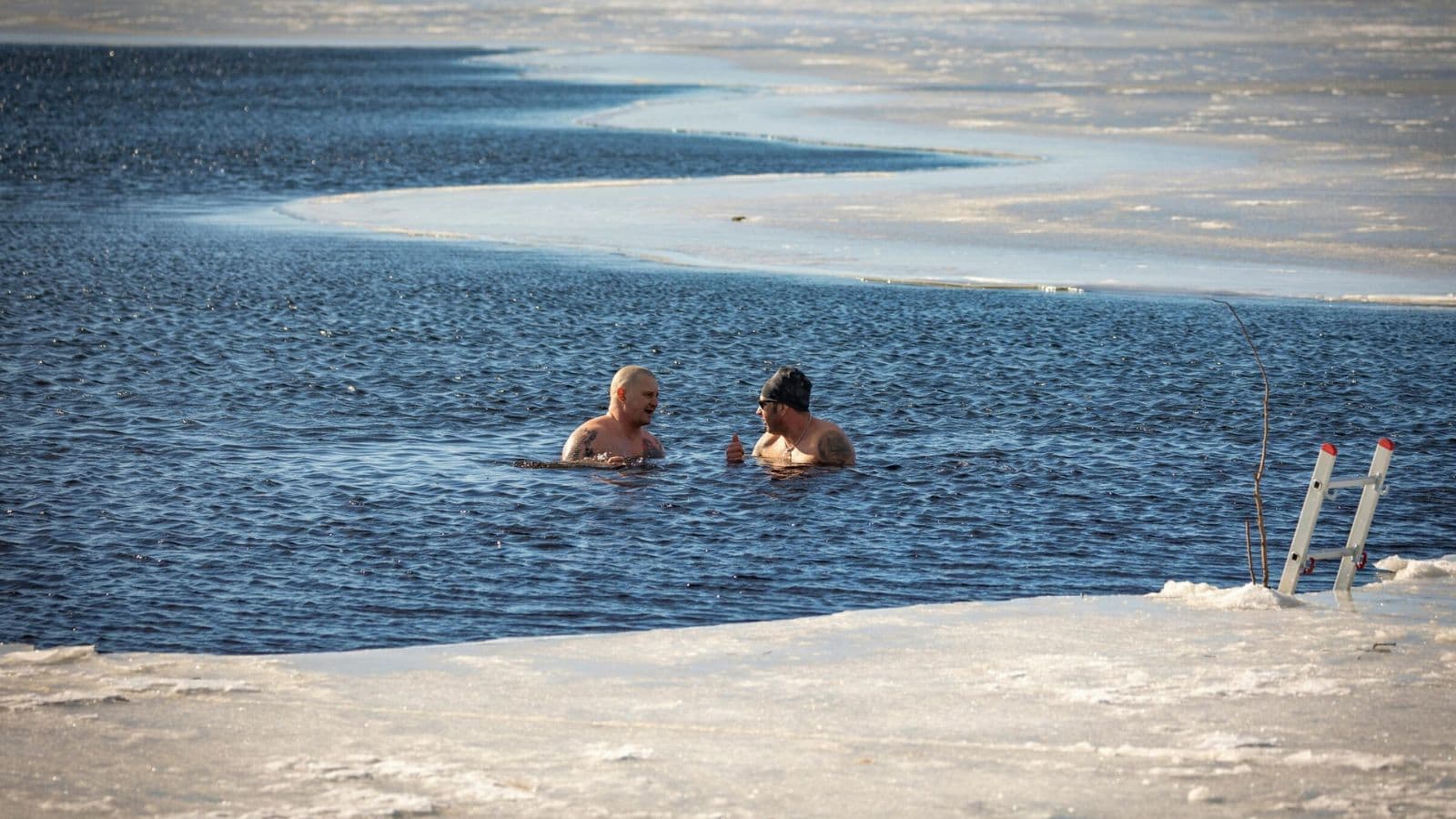 Triathlete immersing tired legs in cold water after completing a demanding triathlon endurance workout.