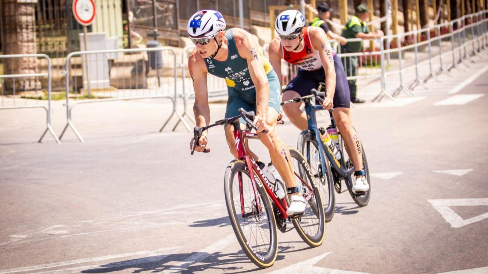 Triathlete checking saddle height on a triathlon bike to improve pedaling efficiency, comfort, and riding position.