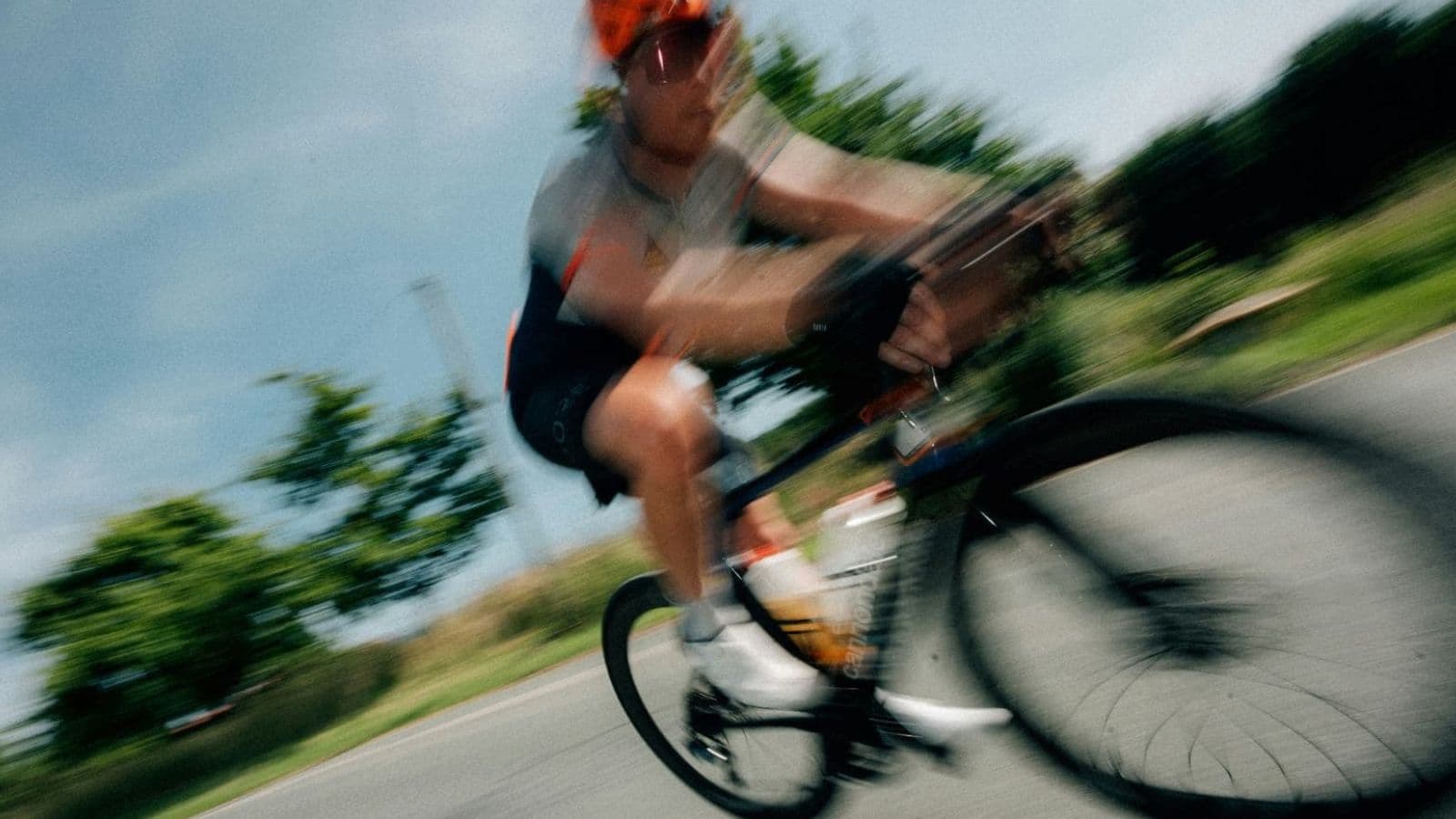 Side view of a triathlete having bike fit measurements checked while riding a triathlon bike on an indoor trainer.