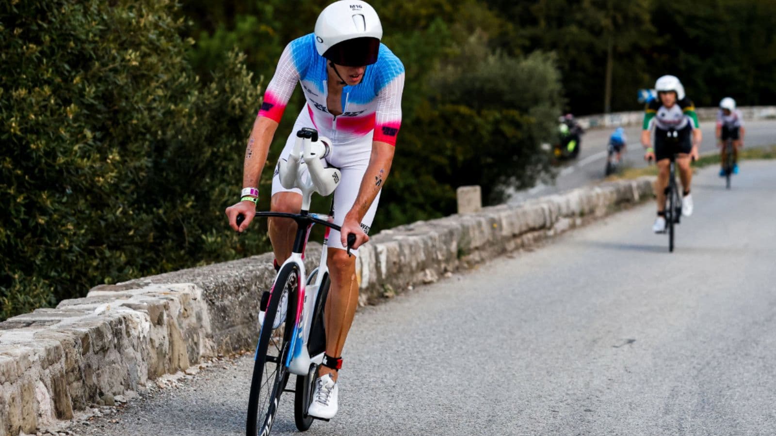 Road cyclist accelerating powerfully from a slower speed during a structured cycling training session.