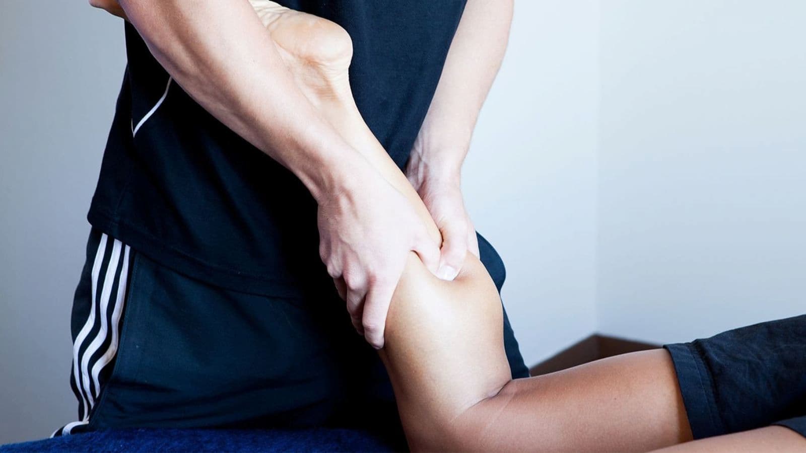 Triathlete receiving a sports massage on tired leg muscles after completing a demanding triathlon race.