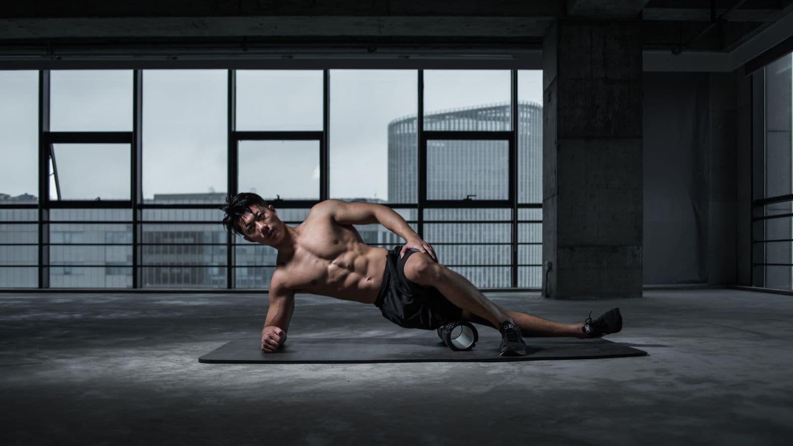 Triathlete using a foam roller on tight quadriceps muscles after completing a demanding cycling and running training session.