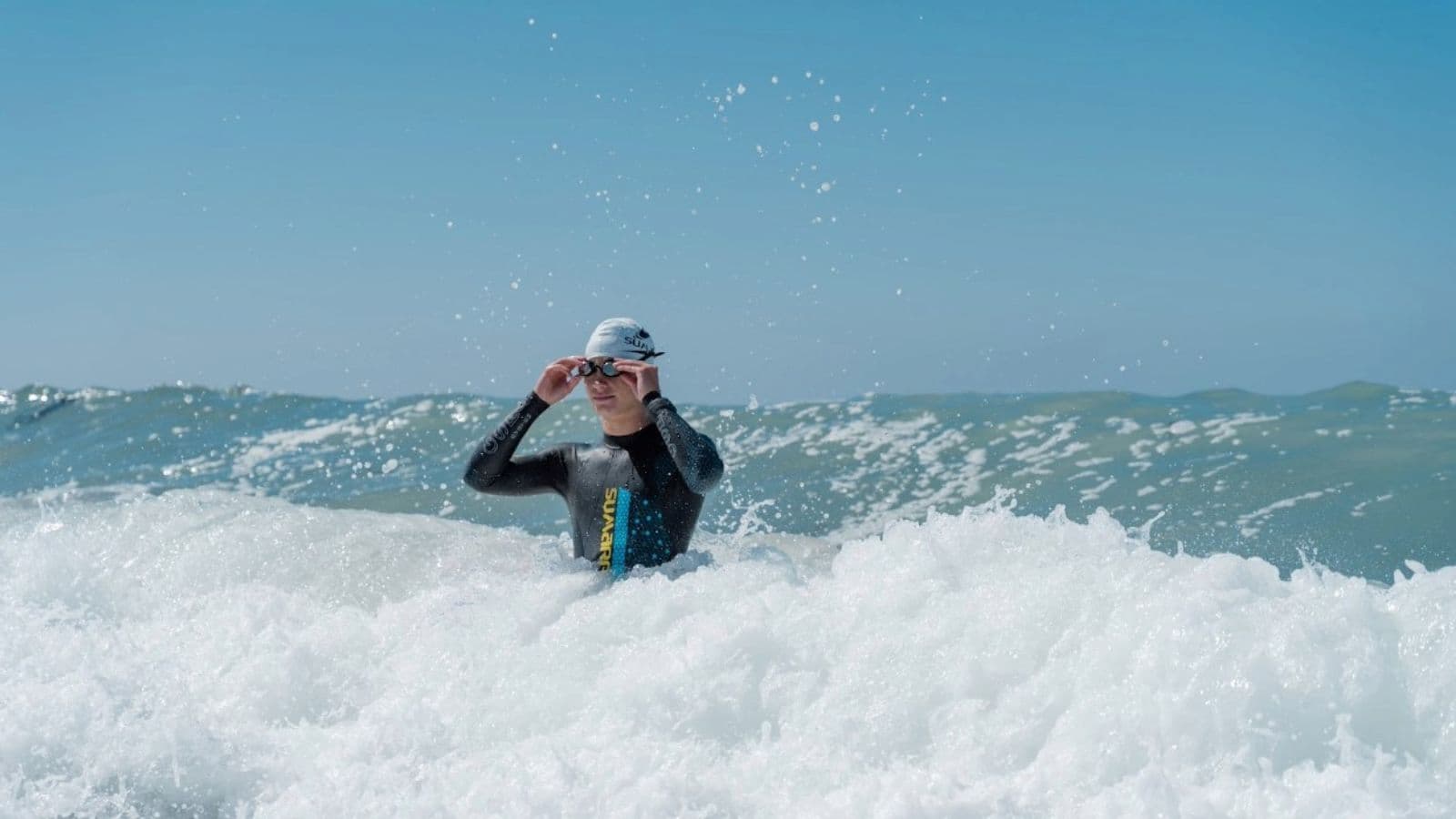 Open water swimmer observing a buoy leaning and moving with the current before beginning a swim.
