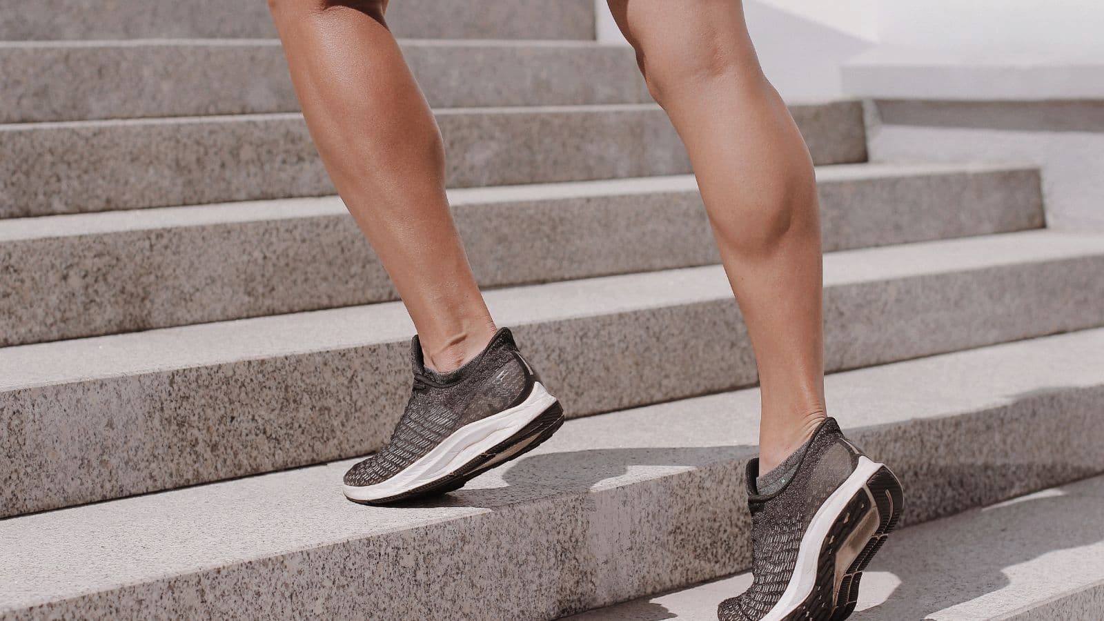 Triathlete beginning the running leg after a demanding bike segment while experiencing fatigue in the calves and lower legs.