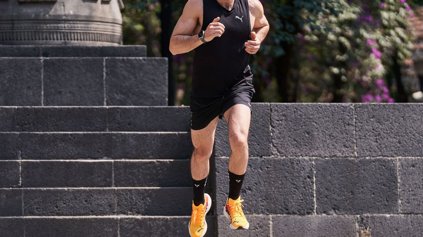 Triathlete stopping during the running leg of a triathlon and holding a painful calf after experiencing a sudden muscle cramp.